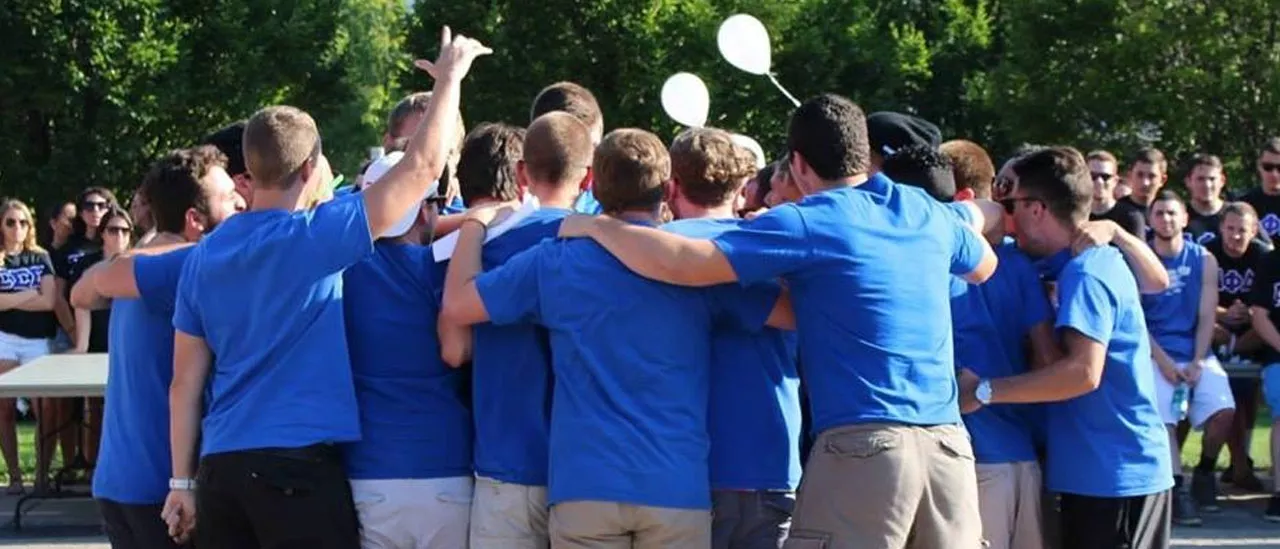 Group of students welcoming a new member to their Greek organization.