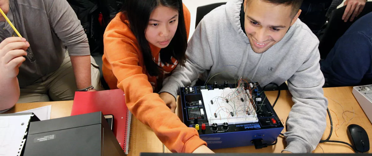 Students working together on wiring a computer.