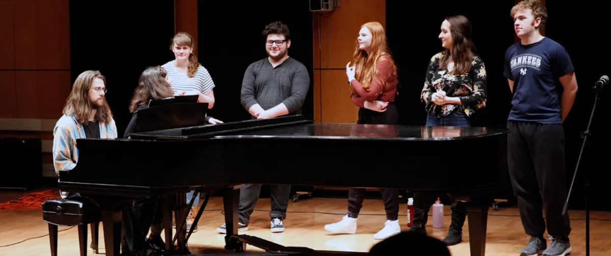 Students performing with a piano accompanying them.