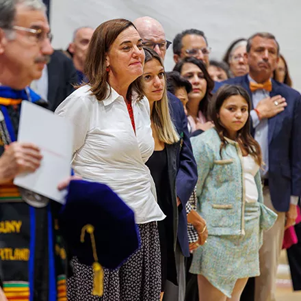 Rachel and daughter watch during speach.