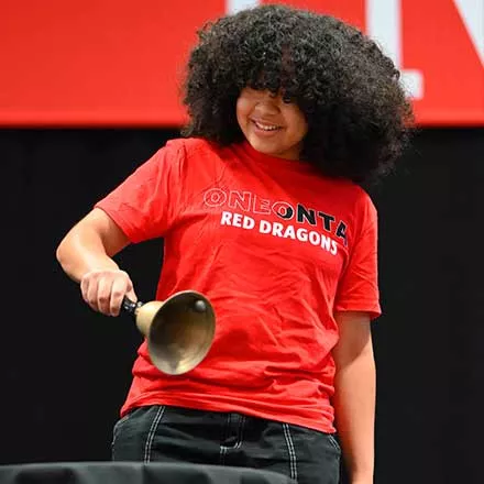 Izzy DeJesus ringing the bell on behalf of her classmates