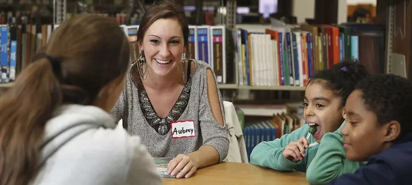 SUNY Oneonta student working with children in a library