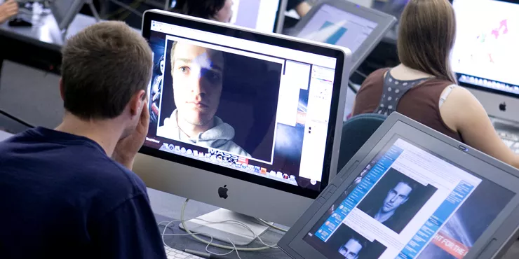 Computer art student editing a photograph on a computer.