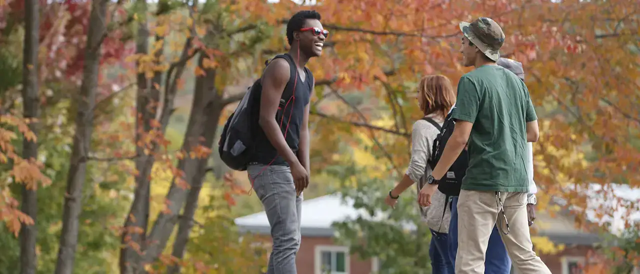 Students talking while walking around campus on a Fall day.