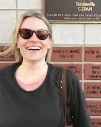 Mette Harder in front of a plaque commemorating Tocqueville's travels in America