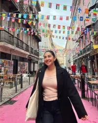 Christina Nunez smiling under banners with the flags of the world.