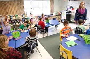 Student teaching children in a classroom.