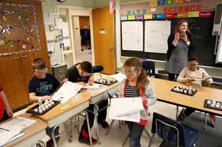 Children drawing with a student teaching them.