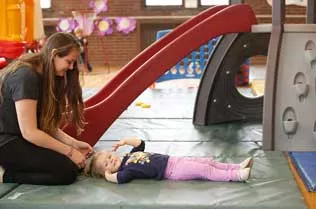 Student braiding a little girl's hair.