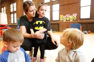 Student hugging a little girl.