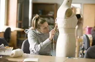 Student measuring clothes on a manikin.