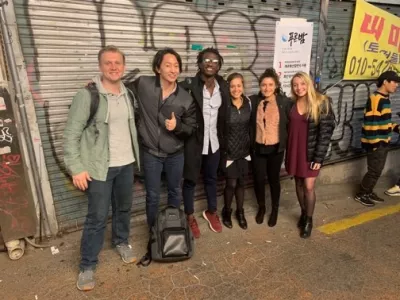 Students posing in front of some street art in South Korea