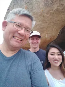 Students and faculty posing in front of a wall of cave drawings.